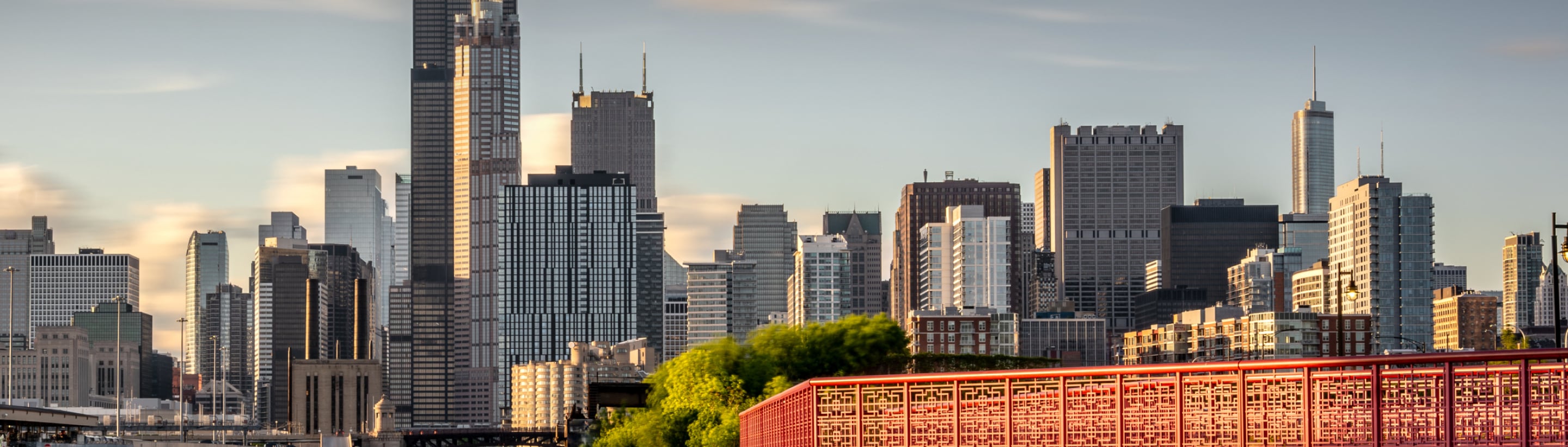 Downtown Chicago skyline at dusk with prominent skyscrapers and city lights.